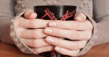 горня кави гріє руки