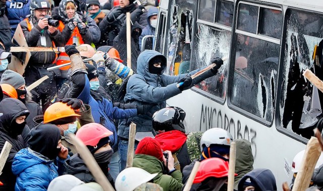 19 січня, друга хвиля протистояння, міліцейські автобуси на Грушевського трощать мітингувальники. фото Reuters