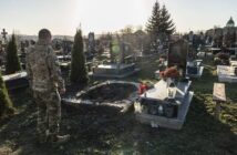 Фото дня: військовий з Львівщини повернувся з полону і прийшов на свою могилу